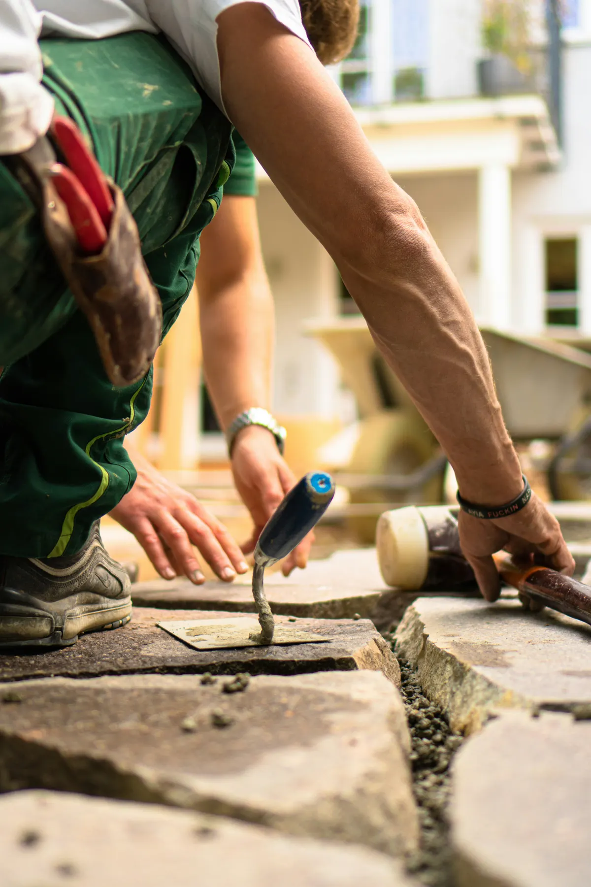 Craftsmen setting stone pavers by hand
